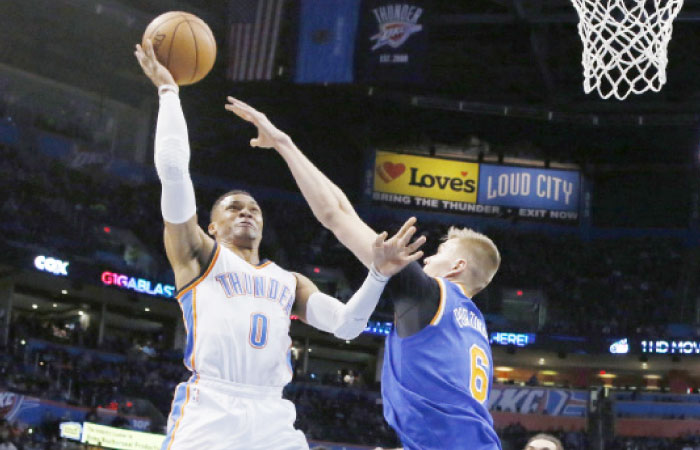 Oklahoma City Thunder’s Russell Westbrook (L) shoots over New York Knicks’ Kristaps Porzingis during their NBA game in Oklahoma City, Wednesday. — AP