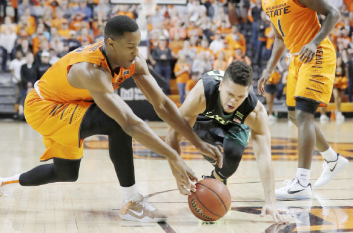 Oklahoma State Cowboys’ forward Cameron McGriff (L) and Baylor Bears’ guard Manu Lecomte dive for a loose ball during their NCAA basketball game at Gallagher-Iba Arena in Stillwater Wednesday. — Reuters