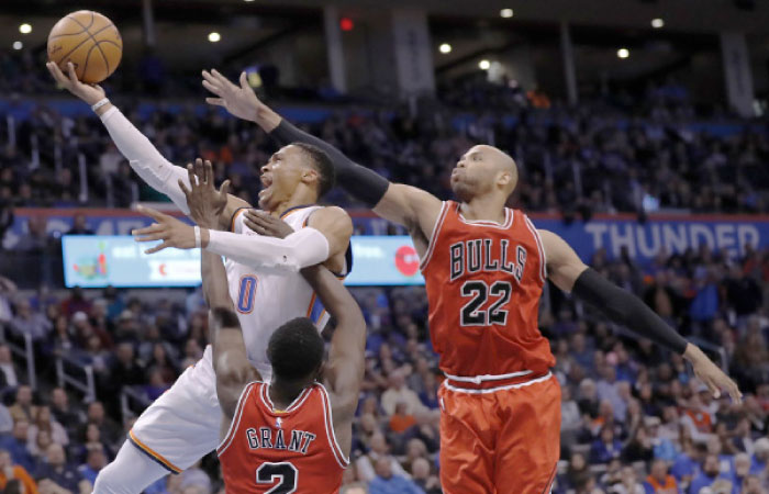 Oklahoma City Thunder’s guard Russell Westbrook goes up for a basket between Chicago Bulls’ guard Jerian Grant (2) and Taj Gibson (22) during their NBA game in Oklahoma City Wednesday. — AP