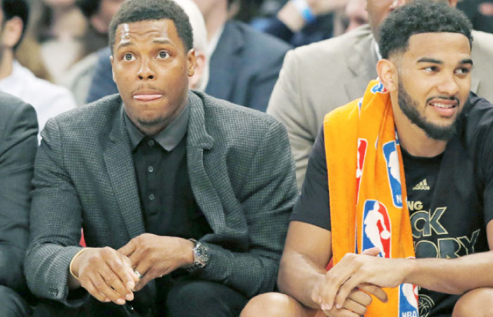 Toronto Raptors Kyle Lowry, who is out with a right wrist injury, sits beside Raptors guard Cory Joseph on the bench during the first half of an NBA basketball game against the New York Knicks at Madison Square Garden in New York, Monday. — AP