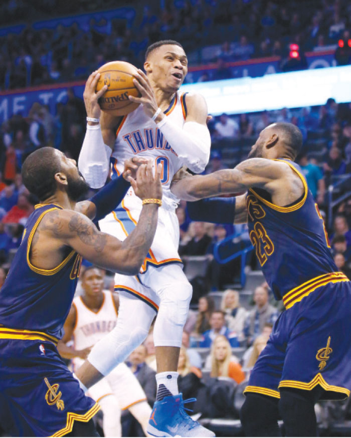 Oklahoma City Thunder guard Russell Westbrook drives between Cleveland Cavaliers’ guard Kyrie Irving (L) and forward LeBron James during their NBA game in Oklahoma City Thursday. — AP