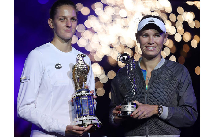 Karolina Pliskova (L) of the Czech Republic and Denmark's Caroline Wozniacki pose with their trophies after the WTA Qatar Total Open final in Doha Saturday. — AFP