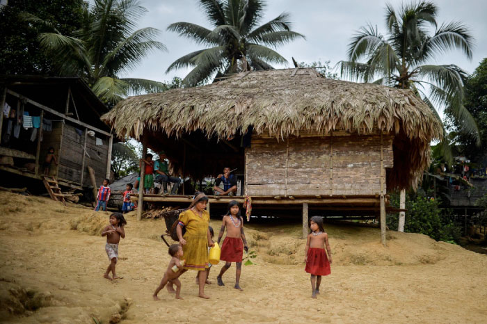 An Embera indigenous woman walks with her children in Puesto Indio, a rural village in Alto Baudo, department of Choco, western Colombia. Despite the peace deal signed by the Colombian government and the FARC rebels, a turf war for control over drug trafficking routes in the isolated department of Choco continues to rage between the smaller ELN guerrilla group and the Autodefensas Gaitanistas de Colombia, a criminal gang that emerged after the paramilitary demobilization a decade ago. — AFP