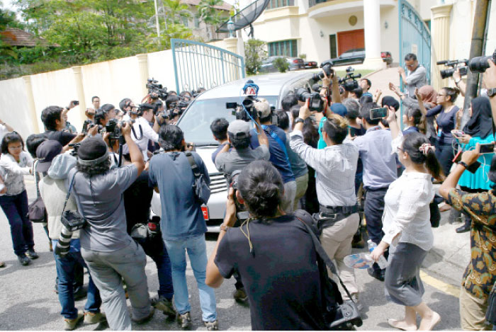 Members of the media surround a North Korea official’s car as it leaves the North Korea embassy in Kuala Lumpur, Malaysia, on Wednesday. — Reuters