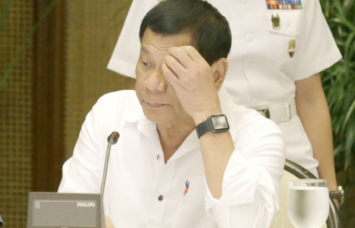 Philippine President Rodrigo Duterte looks at a computer monitor as he arrives for the Armed Forces of the Philippines and Philippine National Police joint command conference at the Malacanang Palace in Manila on Monday. — AP