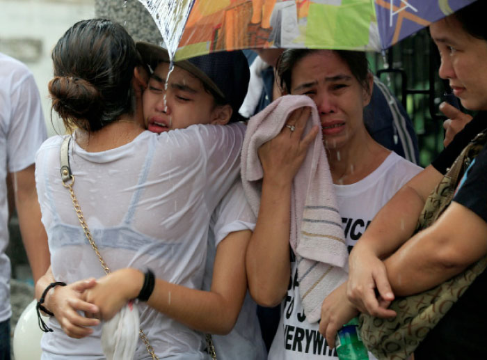 Friends and loved ones of John Jezreel David, 21, who was shot dead in what police said was an anti-drug operation, cry during his funeral rites at the north cemetery in Metro Manila, on Wednesday. — Reuters