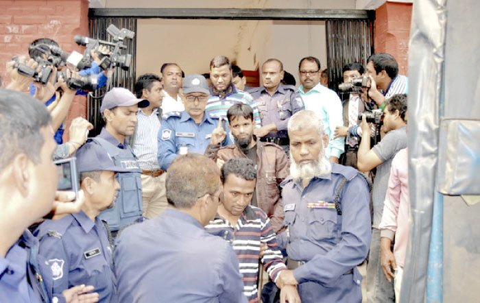 Bangladeshi policemen escort defendants, center, belonging to a militant group, as they are brought to a court in Rangpur, Bangladesh, on Tuesday. — AP