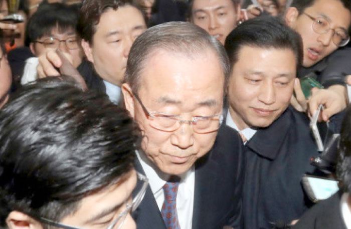 Former United Nations secretary-general Ban Ki-moon, front center, walks past reporters after announcing an end to his attempt to seek South Korea’s presidency at the National Assembly in Seoul on Wednesday. — AFP