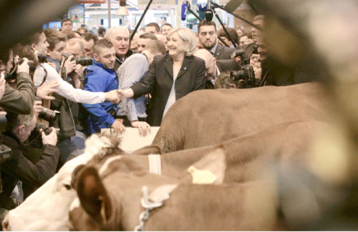 French far-right Front National (FN) party candidate for the presidential election Marine Le Pen, center, visits the Agriculture Fair in Paris on Monday. — AFP