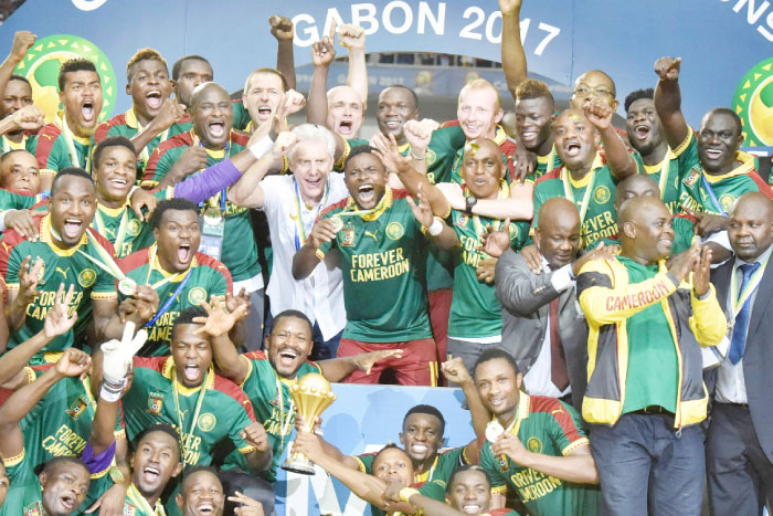 Cameroon team players and Cameroon’s Belgian coach Hugo Broos (C) celebrate with the winner’s trophy after beating Egypt 2-1 to win the 2017 Africa Cup of Nations final football match between Egypt and Cameroon at the Stade de l’Amitie Sino-Gabonaise in Libreville on Sunday. – AFP