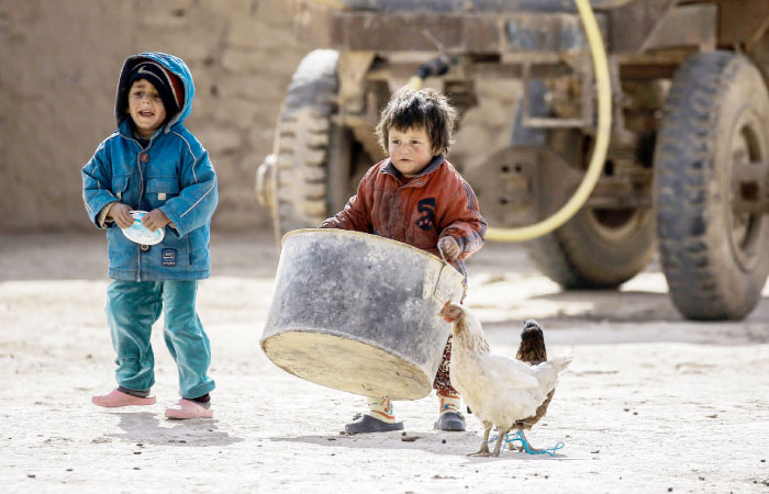 Syrian children from Waset Hashm, a small village east of Raqqa, help their parents gather their belongings as residents of the town prepare to leave their homes to a safer location. — AFP