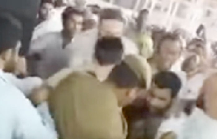 A security person stops a man trying to burn himself in front of the Holy Kaaba in Makkah.