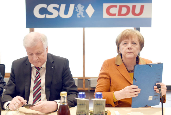 German Chancellor Angela Merkel, also leader of the conservative Christian Democratic Union (CDU), and Horst Seehofer, chairman of the CDU’s sister party, the Christian Social Union (CSU), have taken seat to attend a two-day summit with the leadership of both parties in Munich, southern Germany, on Monday. — AFP