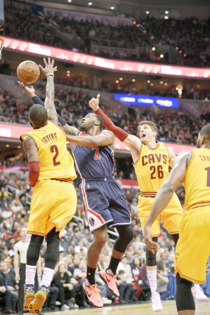 Washington Wizards guard John Wall (2) goes to the basket against Cleveland Cavaliers guard Kyrie Irving (2) and guard Kyle Korver (26) during the second half of an NBA basketball game, Monday in Washington. — AP