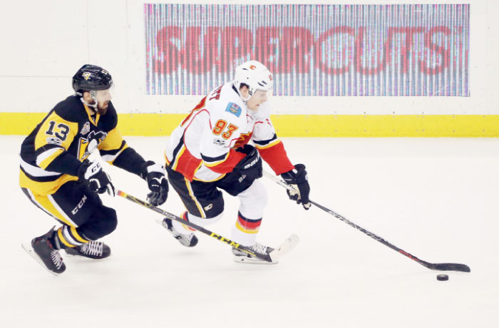 Calgary Flames’ center Sam Bennett (R) skates with the puck as Pittsburgh Penguins’ center Nick Bonino chases during their NHL game at the PPG PAINTS Arena in Pittsburgh Tuesday. — Reuters