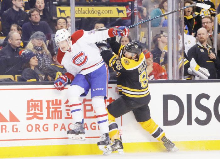 Boston Bruins defenseman Kevan Miller (86) checks Montreal Canadiens right wing Michael McCarron (34) during the third period of the Boston Bruins 4-0 win over the Montreal Canadiens at TD Garden. — Reuters