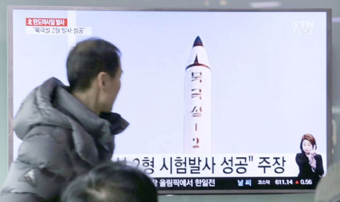 A man watches a TV news program showing a photo published in North Korea’s Rodong Sinmun newspaper of North Korea’s “Pukguksong-2” missile launch, at a railway station in Seoul, on Monday. — AP