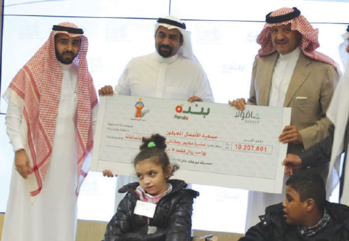 Prince Sultan Bin Salman Bin Abdulaziz Al Saud, Chairman of DCA and President of the Saudi Commission for Tourism and National Heritage, receives the check from Eng. Rayan Mohammad Fayez, CEO of Savola Group and Acting CEO of Panda Retail Company, accompanied by Hesham BaEissa, Public Relations and Corporate Social Responsibility (CSR) Manager and Board Secretary