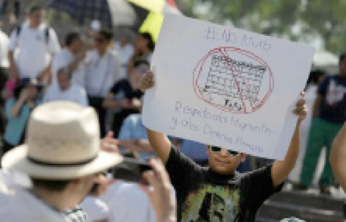 A demonstrator holds a placard reading: “No wall. Respect to immigrants and human rights” during a protest against US President Donald Trump’s proposed border wall and to call for unity, in Monterrey, Mexico, on Sunday. — Reuters