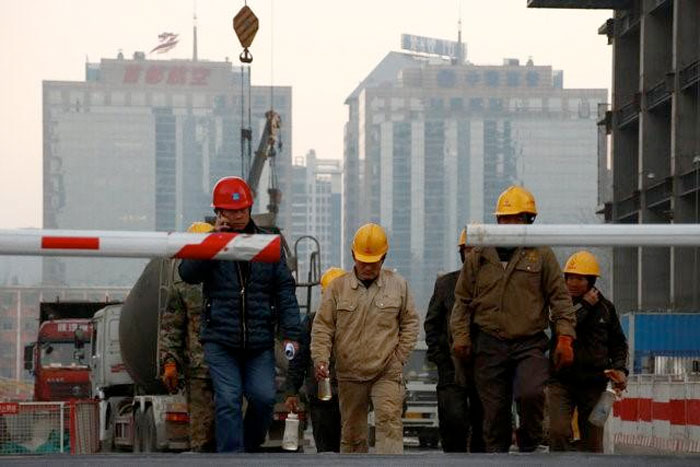 Workers leave a construction site at the end of their shift in Beijing, China December 6, 2016. — Reuters