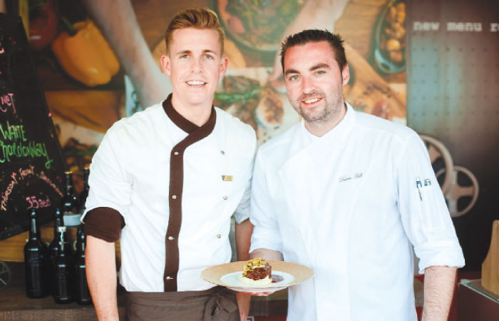 Darren Hall (R), chef de cuisine at Cook Hall, presents his winning dish – beef short rib with horseradish mash – to Etihad in-flight chef Jeremy McPherson (L) at Taste of Dubai