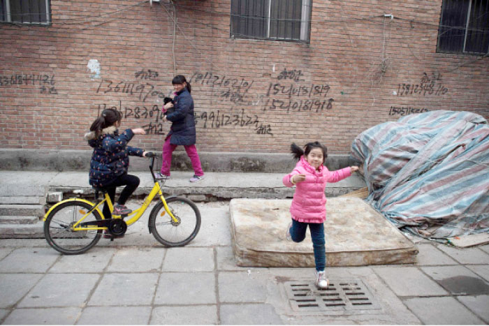 Children playing on a street in the Heiqiaocun migrant village in Beijing. — AFP