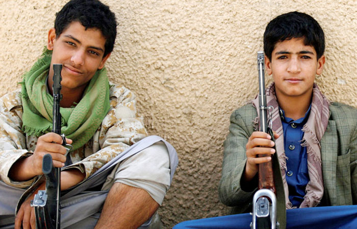 Young Houthi militants sit on the side of a road as they secure a street near the United Nations offices. — Reuters