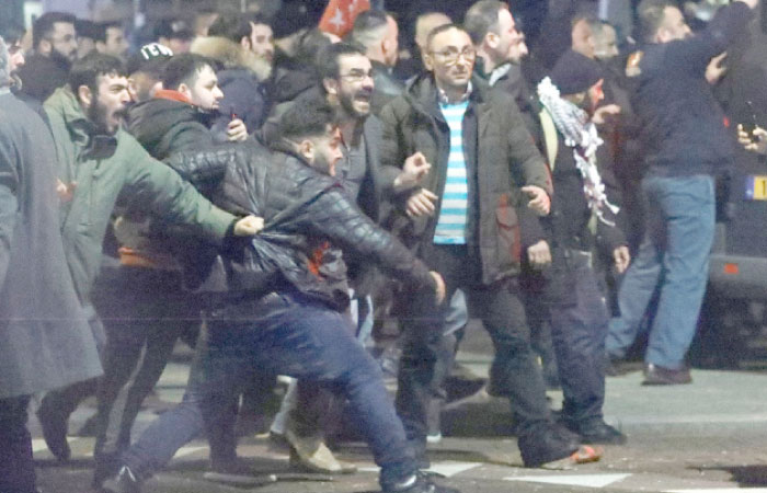 Demonstrators face Dutch riot police outside the Turkish consulate in Rotterdam, Netherlands, Sunday. — Reuters