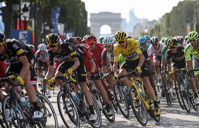 This file photo shows Great Britain's Christopher Froome (4th R), wearing the overall leader's yellow jersey riding in the pack on the Champs-Elysees avenue decorated with French national flag near the Arc de Triomphe during the 113 km twenty-first and last stage of the 103rd edition of the Tour de France cycling race on between Chantilly and Paris Champs-Elysees. — AFP