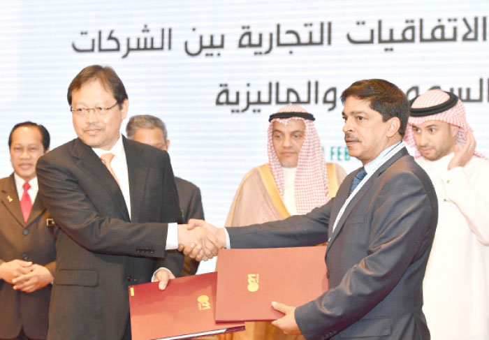 Saudi and Malaysian business leaders exchange documents after signing joint venture and cooperation agreements during the Malaysia-Saudi Arabia Business Forum in Kuala Lumpur on Tuesday. — SPA