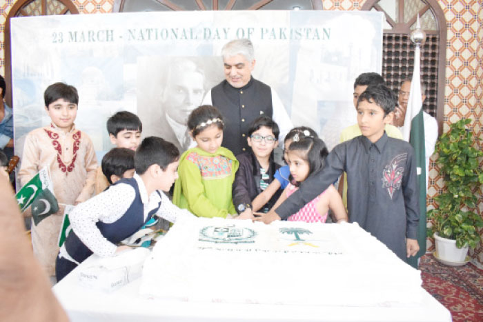 Young children join Consul General Shehryar Akbar Khan in cutting the Pakistan Day cake at his residence. — Courtesy photos