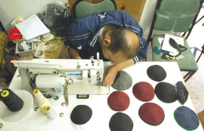 A Palestinian man works in a studio in Gaza City fabricating kippa, or Jewish religious skullcap, to be exported to Israel. Kippas have been fabricated in this Palestinian workshop since the early 90s. After the Hamas Islamist party took control of the Gaza Strip in 2007 exports have decreased by half. —AFP