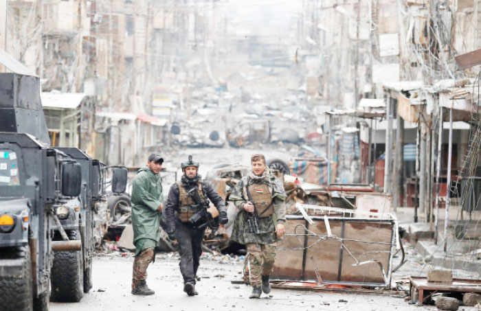 Iraqi special forces soldiers walk in a street in Mosul. — Reuters