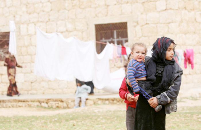 Displaced Syrians, who fled their hometowns due to clashes, stand in Kharufiyah, 18 kilometer south of Manbij. — AFP