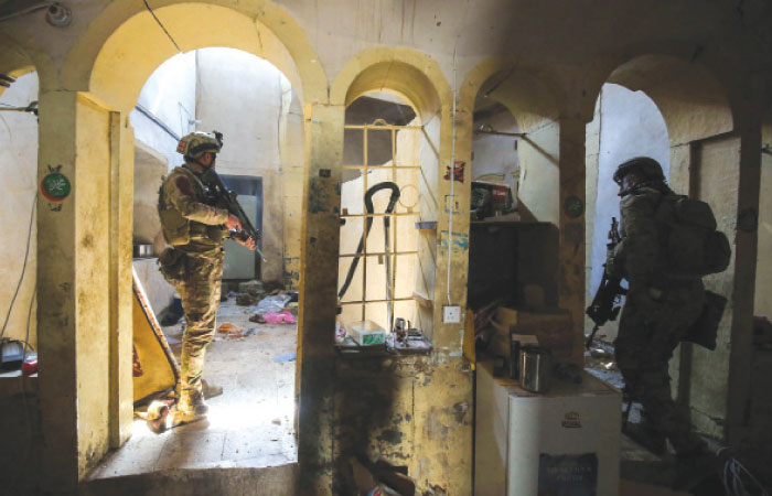Iraqi forces, consisting of the Iraqi federal police and the elite Rapid Response Division, advance in a house in the Old City in western Mosul on Friday, during the offensive to retake the city from Daesh group fighters.  — AFP