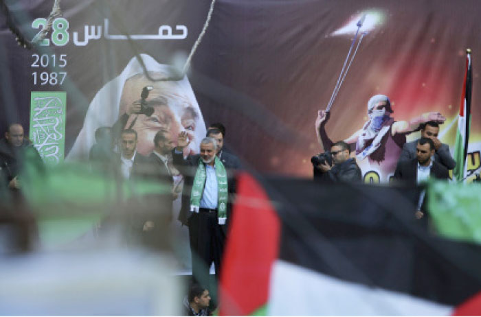 In this file photo, Hamas leader Ismail Haniyeh waves to supporters during a rally to commemorate the 28th anniversary of the Hamas in Gaza City. Hamas has drafted a new political program that it hopes will improve ties with neighboring Egypt and the West and present a more moderate image that will help it get off Western terrorism lists. — AP