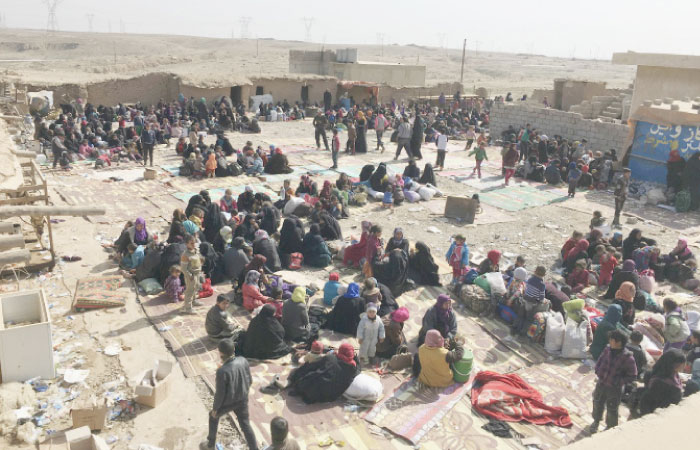 Displaced Iraqis who fled their homes due to fighting between security forces and Daesh militants wait to be transferred to camps for displaced people, west of Mosul, Tuesday. — AP