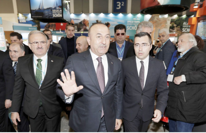 Turkish Foreign Minister Mevlut Cavusoglu (center) arrives for a visit of the booth of Turkey at the tourism fair ITB in Berlin, Germany, Wednesday. — AP