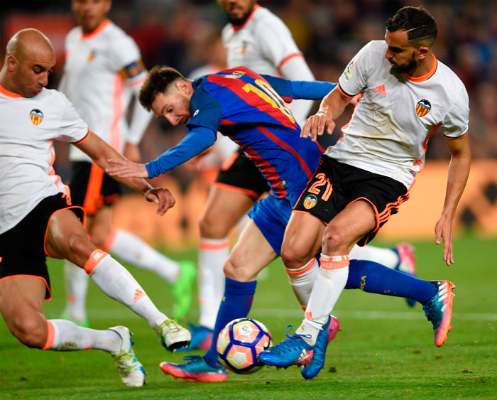 Barcelona's Argentinian forward Lionel Messi (C) vies with Valencia's defender Martin Montoya (R) and Valencia's Tunisian defender Aymen Abdennour (L) during the Spanish league football match at the Camp Nou stadium in Barcelona on Sunday. — AFP