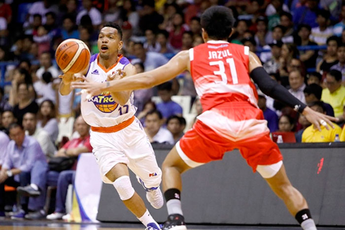 TNT's Jayson Castro passes the ball off Phoenix's RJ Jazul in the PBA Commissioner's Cup at the Ynares Center in Antipolo Sunday night.