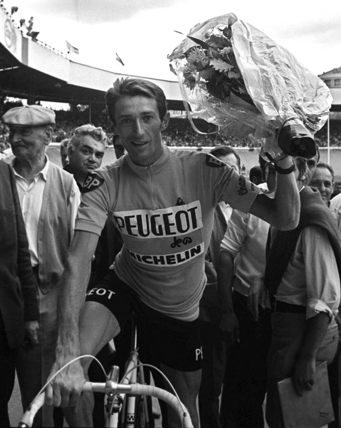 This file photo taken on July 23, 1967 shows Frenchman Roger Pingeon posing for photographers with a bouquet of flowers in his hand after winning the Tour de France, in Paris. — AFP