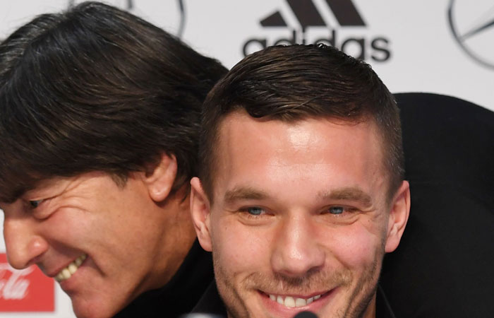 Germany's midfielder Lukas Podolski smiles as Germany's head coach Joachim Loew gives him a hug, during a joint press conference in Dortmund, western Germany, on Tuesday, one day ahead of the friendly match between Germany and England, Podolski's last match with the German team. — AFP