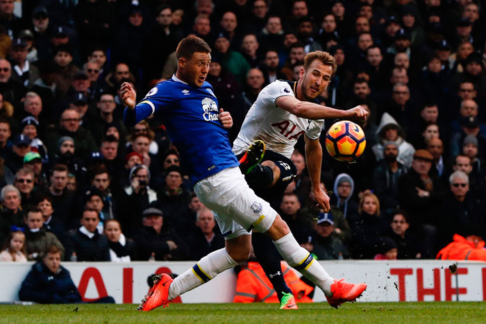 Tottenham Hotspur's striker Harry Kane (R) shoots past Everton's midfielder James McCarthy during their English Premier League match at White Hart Lane in London Sunday. — AFP