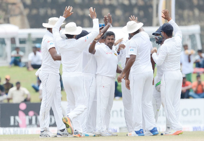 Sri Lanka’s Rangana Herath celebrates with his teammates during the first cricket Test against Bangladesh at Galle Stadium Saturday. — AFP