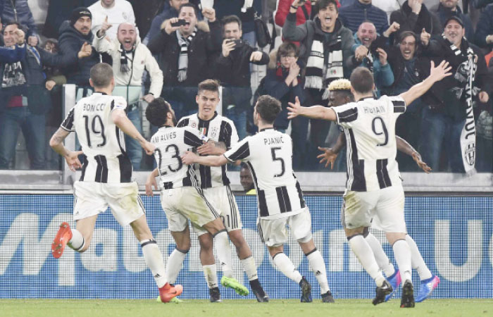 Juventus players celebrate after beating AC Milan in their Italian Serie A match at the Juventus Stadium in Turin Friday. — Reuters