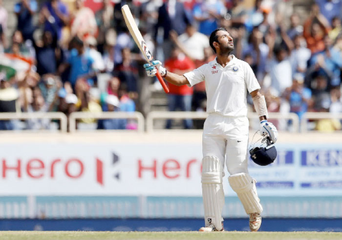 India’s Cheteshwar Pujara looks skywards and raises his bat to celebrate scoring a century during the third day of the third Test cricket match against Australia in Ranchi, India, Saturday. — AP