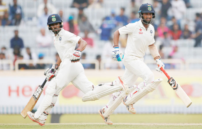 India’s Cheteshwar Pujara (R) and Wriddhiman Saha run between the wickets during the third Test cricket match against Australia at the Jharkhand State Cricket Association Stadium, Ranchi, Sunday. — Reuters