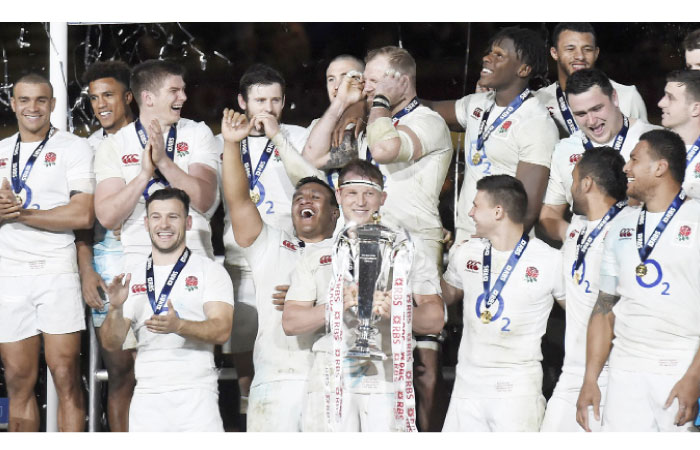 England’s players celebrate with the Six Nations Trophy despite losing to Ireland at the Aviva Stadium in Dublin Saturday. — Reuters