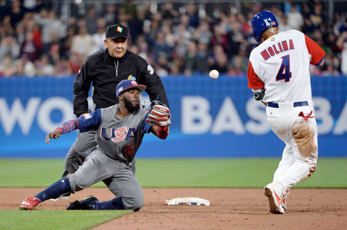 San Diego, CA, USA; Puerto Rico catcher Yadier Molina (4) reaches second base on an error by United States infielder Brandon Crawford (26) during the 2017 World Baseball Classic at Petco Park. — Reuters