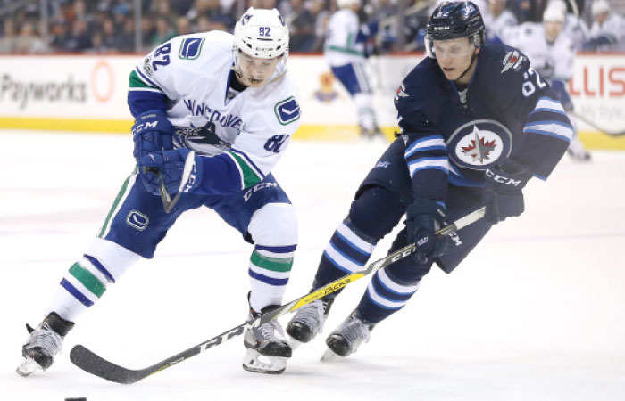 Winnipeg Jets defenseman Nelson Nogier (62) knocks the puck away from Vancouver Canucks right wing Nikolay Goldobin (82) during the third period at MTS Centre. Winnipeg Jets win 2-1. — Reuters